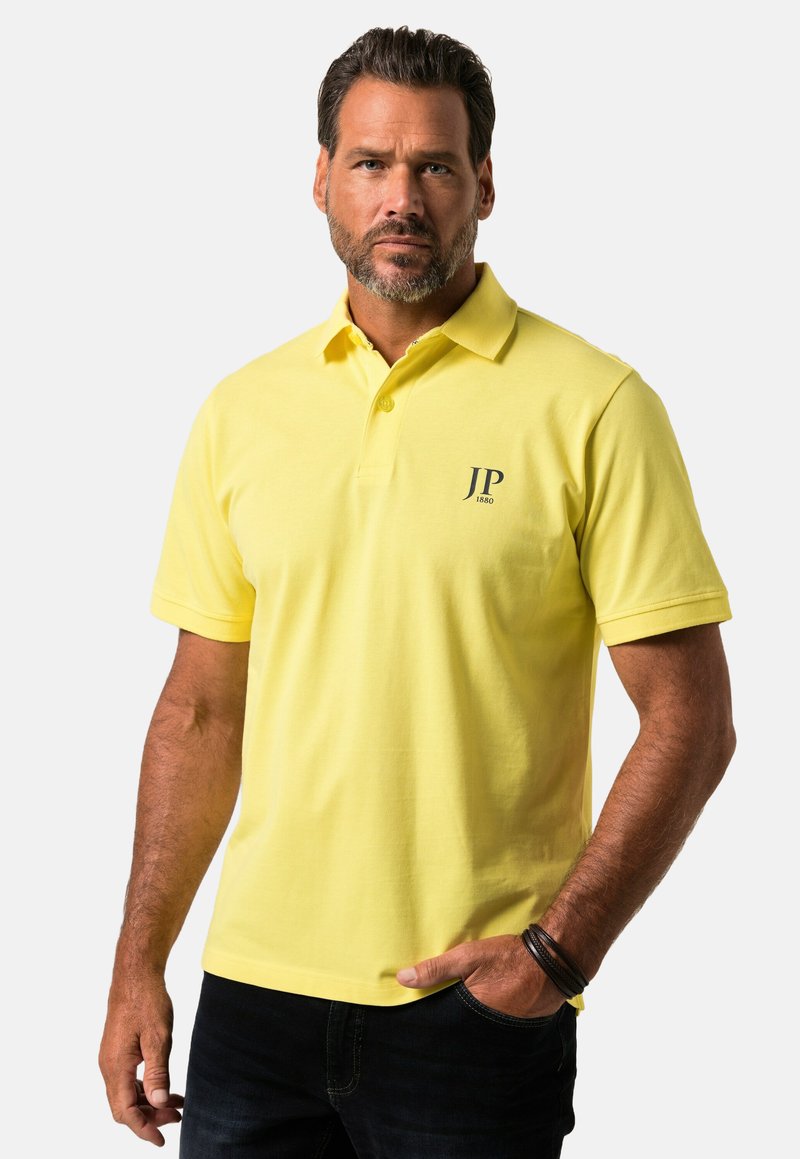 Gul polo shirt lavet af bomuld med en kort krave, der har et mørkt logo "JP 1880" på venstre side. Casual fit med korte ærmer.
