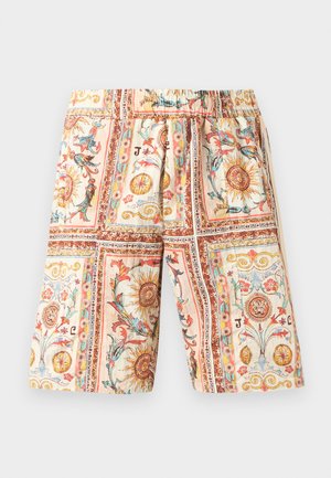 Kniestokorte broek met elastische taille, voorzien van kleurrijke, sierlijke zon- en bloemenpatronen in rechthoekige panelen op een beige achtergrond.