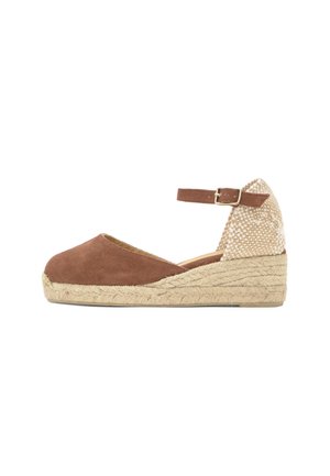 Bruine stoffen wedge espadrille met enkelriem en gespsluiting, met gevlochten jute hiel en zoolplatform, schuine zijaanzicht op witte achtergrond.
