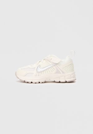 Šviesiai smėliniai sportbačiai su tinklelio viršumi, tekstūruotais akcentais ir balta Nike swoosh logo. Yra apvalus pirštas ir paminkštintas padas patogumui.