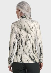Langärmliges Oberteil mit einem strukturierten, abstrakten Muster in verschiedenen Weiß- und Grautönen. Es verfügt über einen hohen Kragen und ein figurbetontes Design.