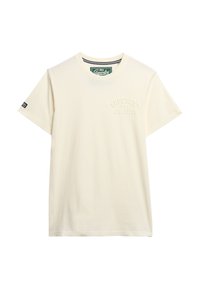 Camiseta de algodón color crema con cuello redondo, mangas cortas y logo embosado de "Superdry" en el lado izquierdo. Corte estándar.