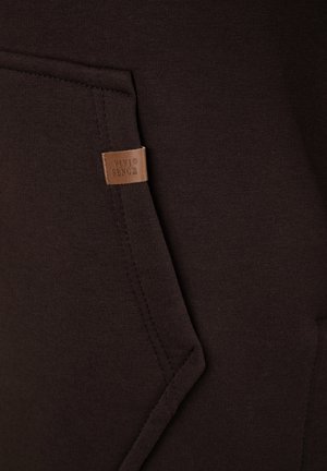 Barna kapucnis pulóver anyag sima tapintású, elöl varrt zsebbel és oldalt márkajelzett bőr címkével.