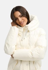 White puffer jacket with a high collar and adjustable drawstring. Features padded sections, snap buttons, and side pockets. Smooth texture.
