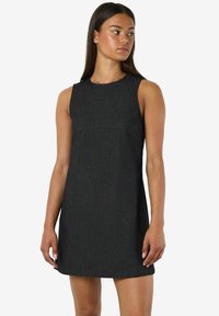 Bez piedurknēm izgatavota kleita tumši pelēkā audumā ar gludu tekstūru, ar pieguļošu augšdaļu un izplestu svārku, maigi šuvju akcenti krūtīs.