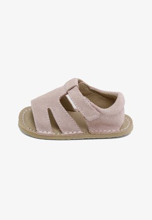 Sandalia blanda rosa para niño pequeño con punta abierta, tres tiras horizontales y cierre de velcro sobre una suela beige con costuras blancas.