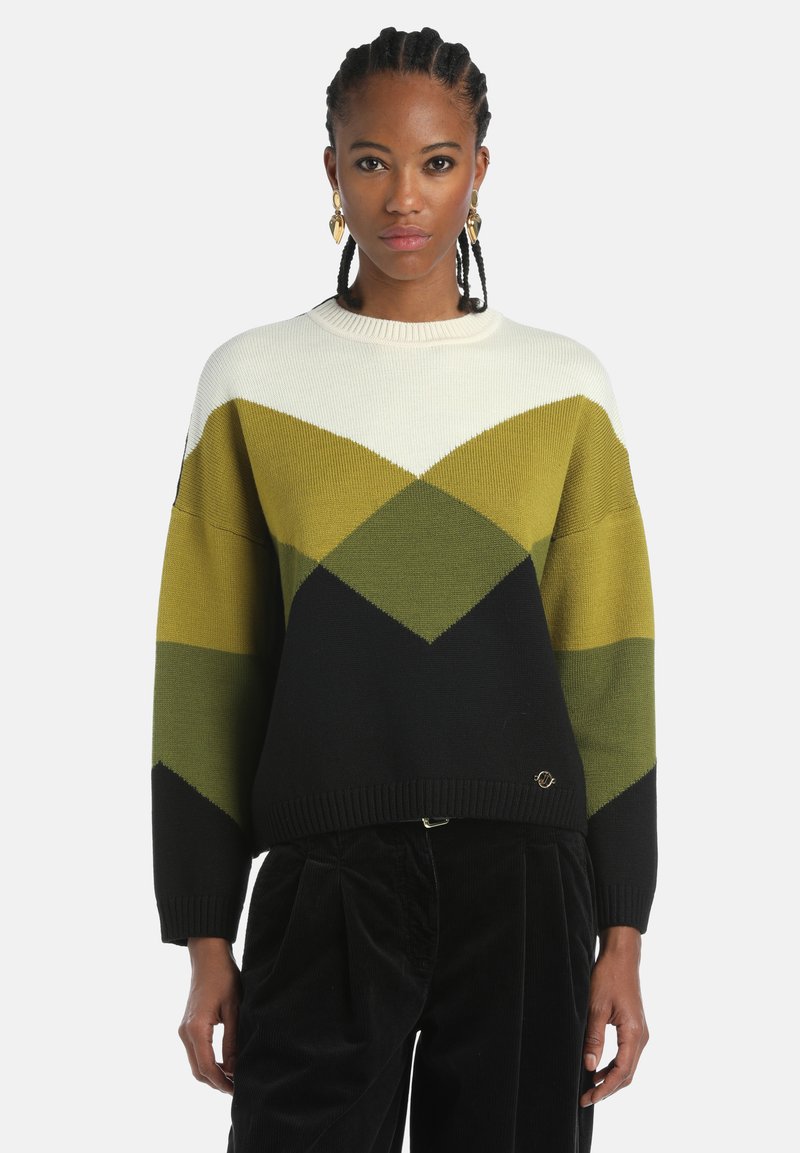 Pulover tricotat cu un model geometric în verde, negru și crem, cu un guler și mansete ribate. Detaliu cu logo aproape de tiv.