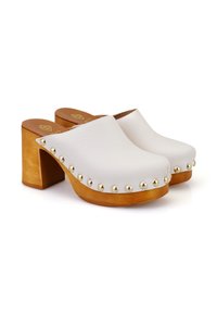 Sabots en cuir blanc avec un bout arrondi, un talon en bloc de bois et des clous dorés le long du bord extérieur. Texture lisse et design à dos ouvert.