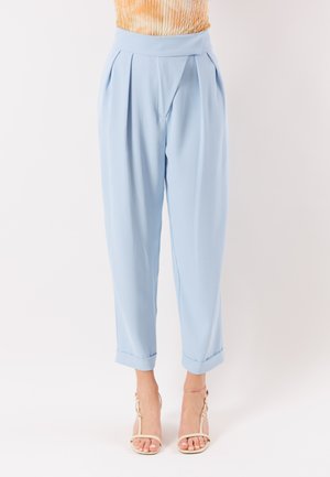 Pantaloni a vita alta azzurri chiaro a gamba stretta con pieghe e orli risvoltati indossati con sandali beige con cinturino alla caviglia e tacco.