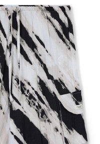 Schwarz-weißer, plissierter Rock aus leichtem Stoff, der ein abstraktes Pinselstrichmuster und eine aufgesetzte Tasche mit Etikettendetail aufweist.