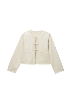 Veste cropped beige clair en tissu à texture lisse, dotée de trois fermetures à bouton et de deux poches avant.
