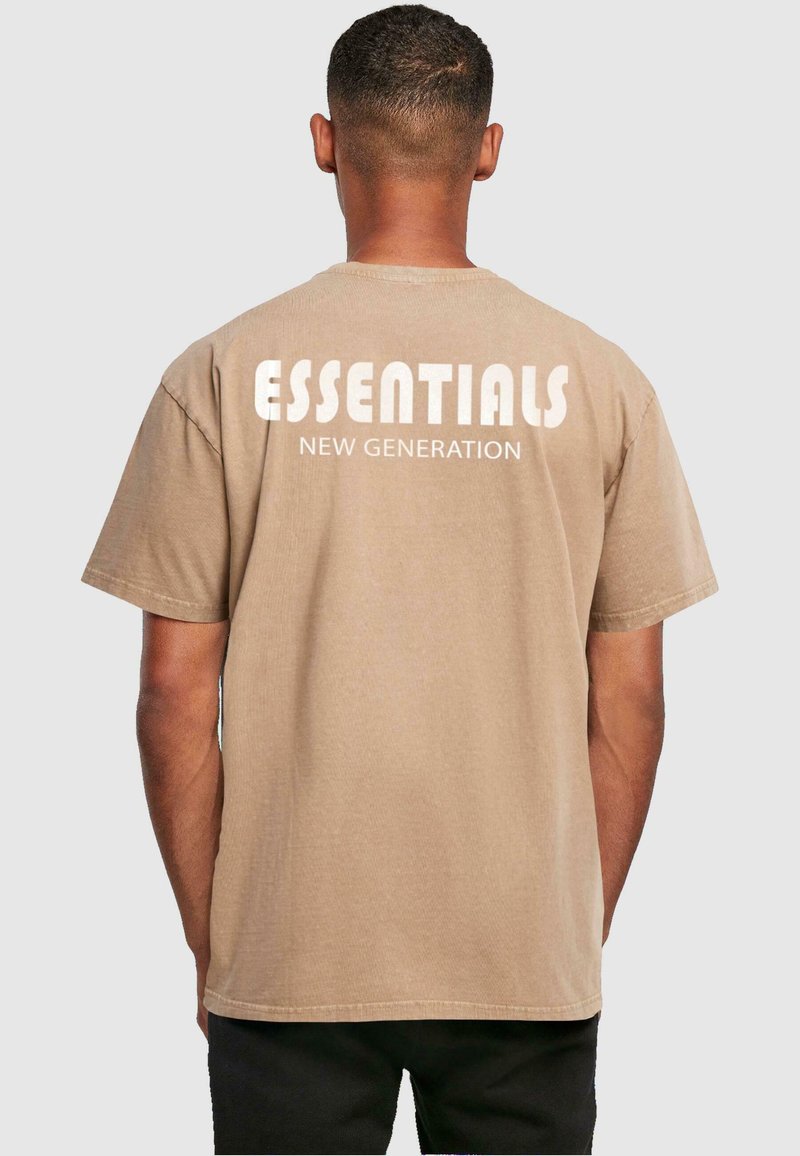 Brun bomulds T-shirt med korte ærmer, der har hvid tekst "ESSENTIALS NEW GENERATION" hen over ryggen. Enkel design med en afslappet pasform.