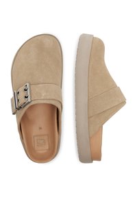 Beige velúr slip-on cipő széles pánttal és csattal, vastag, világosszürke talppal a kényelme és a magassága érdekében.