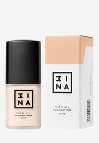 Fondotinta 3-in-1 in una bottiglia di vetro satinato con tappo a vite nero, accompagnato da un cartone beige e bianco etichettato SPF 15.