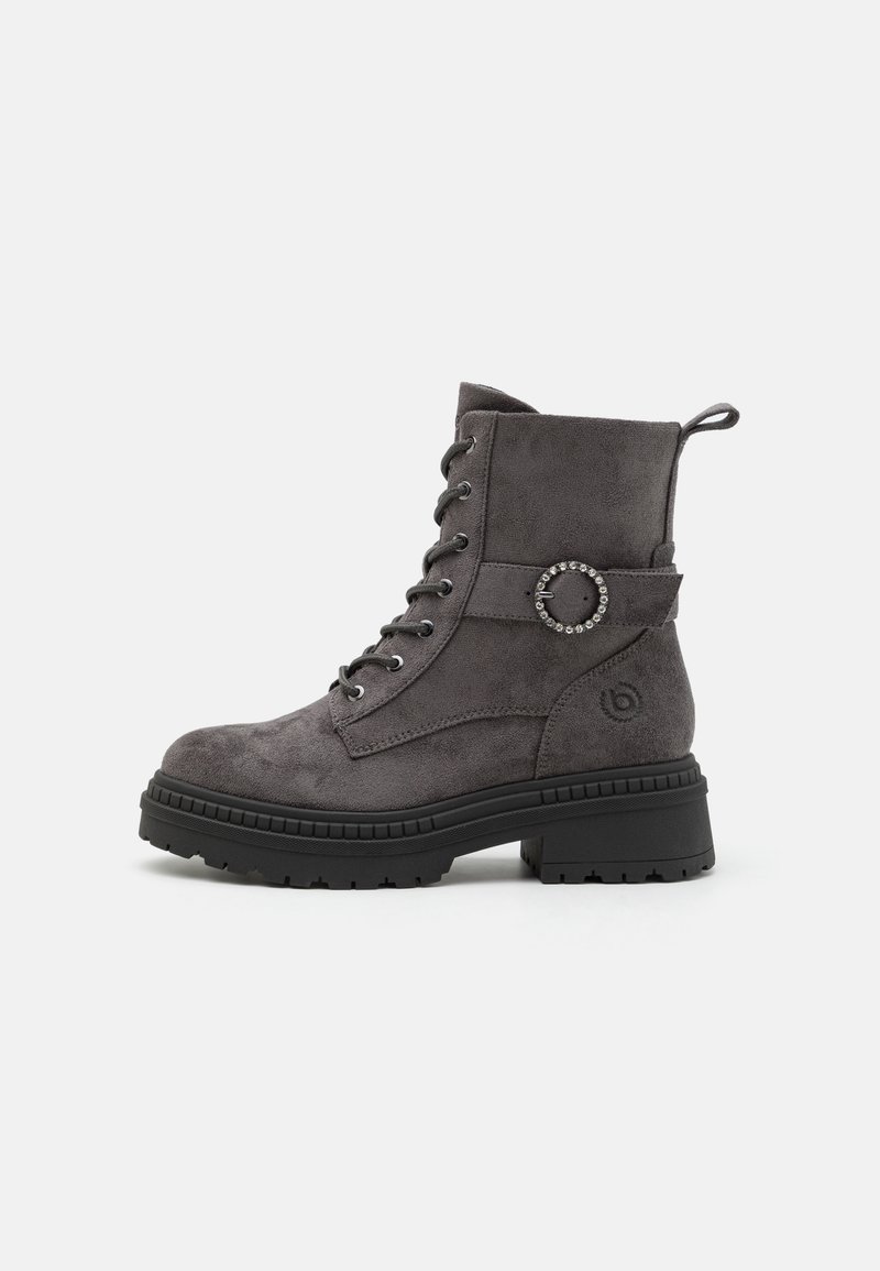 Bottines en suede gris avec un bout rond, un laçage sur le devant, un accent en boucle ronde et une semelle en caoutchouc noire épaisse. Dotées d'une languette au dos.