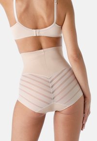Shorts modellanti a vita alta color beige con finitura liscia, dotati di pannelli a strisce trasparenti e design senza cuciture per comfort e supporto.