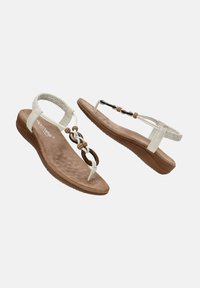 Sandalias de dedo blancas con una plantilla texturizada, tacón plano y adornos decorativos retorcidos en marrón y beige. Suela de goma para mayor tracción.