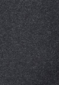 Mörkgrått stickat tyg på nära håll som visar texturerade fibrer och ett mjukt, lurvigt ytmönster.