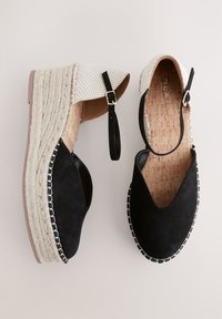 Paar Keil-Espadrilles mit schwarzer Velourslederkappe, beige gewebtem Absatz, geflochtener Jutesohle und verstellbaren schwarzen Knöchelriemen mit goldenen Schnallen.