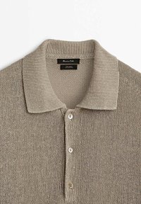 Beige knitted polo shirt with a ribbed collar, five button placket, and a textured pattern made from linen material.
