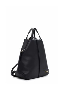 Mustast nahast kolmnurkse kujuga seljakott, millel on lukuga tasku, kaks õlarihma ja väike kuldne logo.