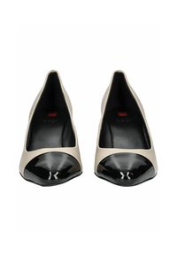 Beige kožené baleríny s černým lakovaným špičkou, s kulatým tvarem a nízkým střihem, který odhaluje vnitřní podšívku.