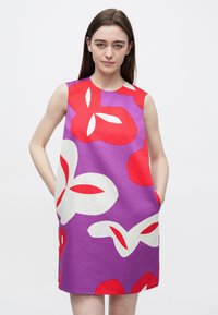 Έγχρωμο αμάνικο φόρεμα κατασκευασμένο από απαλό ύφασμα με μεγάλα κόκκινα και λευκά λουλουδένια σχέδια σε μοβ φόντο. Περιλαμβάνει πλαϊνές τσέπες.