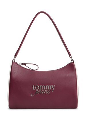 Sac à main en cuir violet avec une fermeture éclair incurvée sur le dessus et une fine bandoulière, avec le logo argenté "tommy jeans" à l'avant.