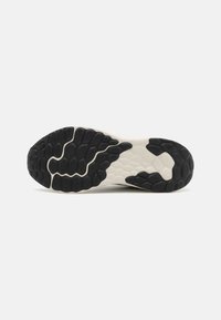 Sort og hvid sneakersål med tekstureret gummigrebs mønster, der har et asymmetrisk design og en polstret, fleksibel mellemsål.