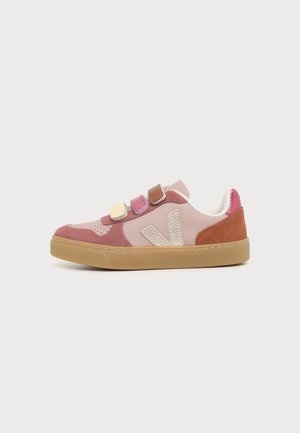 Low-top sneaker met roze en roestkleurige suède panelen, beige "V"-logo, drie gekleurde klittenbandsluitingen en een rubberen zool op witte achtergrond.