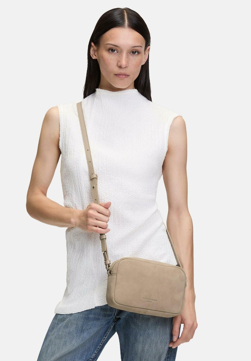 Borsa a tracolla in suede beige con forma rettangolare liscia, cinturino regolabile e design minimalista. Finitura testurizzata sul materiale.