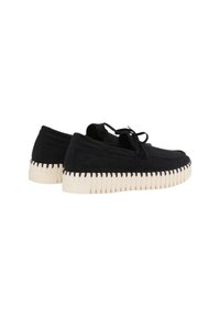 Mocasines de ante negros con suela de goma blanca texturizada. Presentan un diseño de cordones y costuras visibles a lo largo de los bordes.
