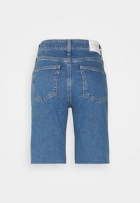 Modré džínové kraťasy s vysokým pasem, se dvěma zadními kapsami a bílou značkovou etiketou na pásku, vystavené na bílém pozadí.