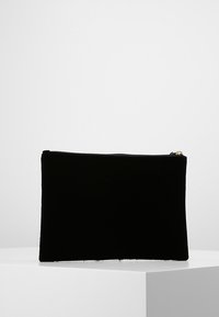 Svart sammetspåse med en slät yta och dragkedjestängning. Rektangulär form, minimalistisk design, lämplig för förvaring av små föremål.