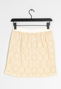 Žlutá vzorovaná sukně s krémovým elastickým pasem. Obsahuje geometrický design vzájemně propojených kruhů na světle b éžovém pozadí.