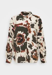 Bluse med blomsterprint i creme, med nuancer af brun, grøn og pink. Knappet foran, krave og lange ballonærmer. Tekstureret stof.