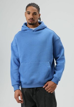 Lichtblauwe hoodie gemaakt van zachte stof, voorzien van een ruime voorzak, geribbelde manchetten en een comfortabele, losse pasvorm.