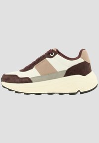 Sneaker décontracté à tige basse en marron, beige et blanc cassé avec lacets à l’avant et semelle blanche épaisse, vue de côté sur fond neutre.