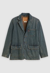 Blazer de mezclilla con tres botones, un bolsillo en el pecho con etiqueta roja y dos grandes bolsillos frontales con solapa, colocado sobre un fondo blanco.