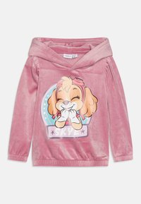 Sudadera de terciopelo rosa con una gran ilustración de un perro de dibujos animados con pelaje marrón, que lleva gafas rosas, y el nombre "SKYE" en la parte inferior.
