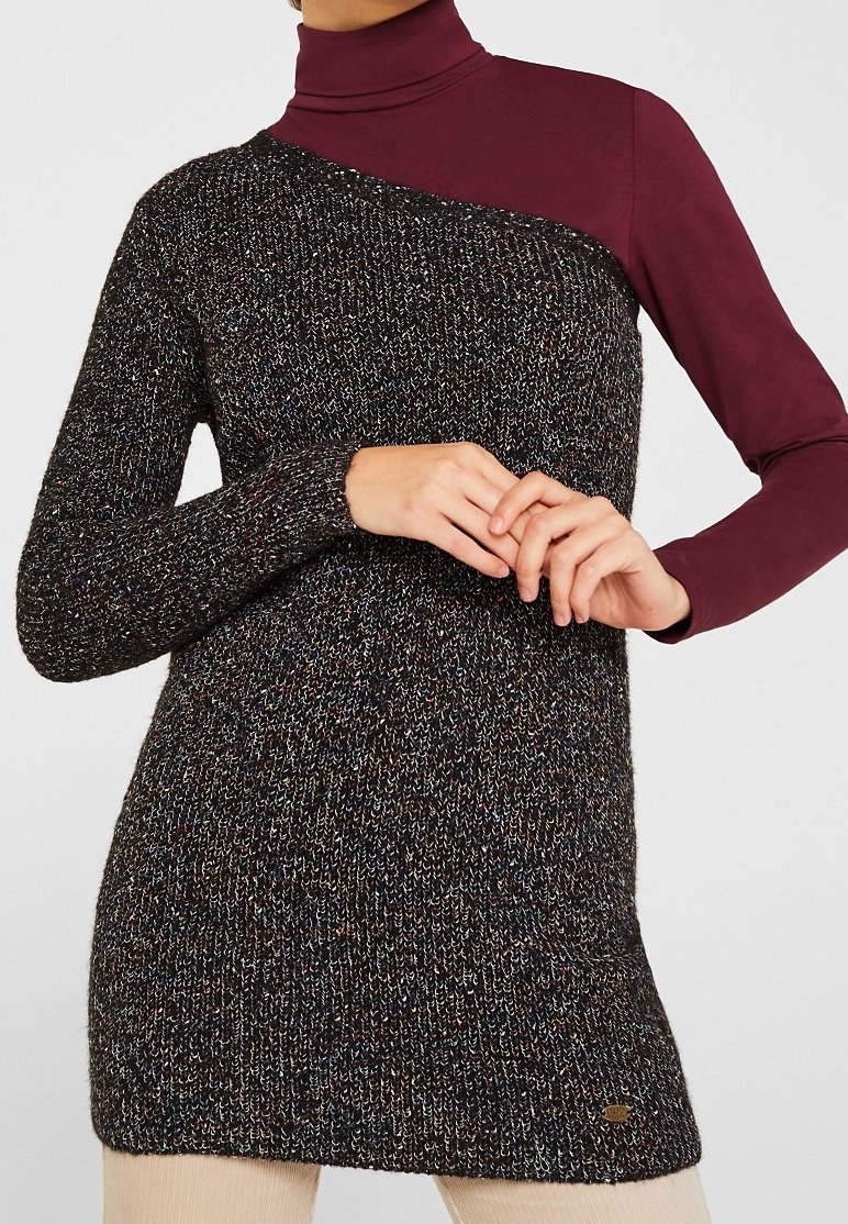 Zwarte en veelkleurige gebreide sweater jurk met een col. Het heeft een asymmetrisch ontwerp met een effen bordeauxrode sectie op één schouder.