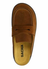 Chaussure slip-on en daim brun avec une texture lisse, dotée d'un nœud décoratif et de surpiqûres contrastées. À l'intérieur, une doublure beige avec un logo.