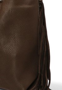 Bolso de cuero marrón con superficie texturizada, que presenta largas franjas a lo largo del costado como detalle. Sin herrajes ni acentos visibles.
