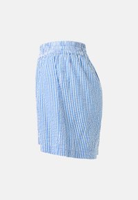 Jupe à rayures verticales bleues et blanches avec taille élastique et plis sur fond gris clair.
