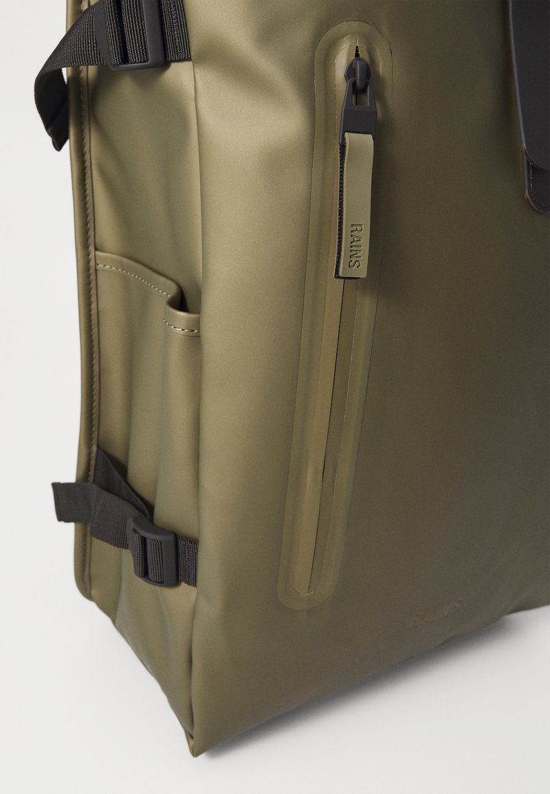 Sac à dos imperméable vert olive avec une texture lisse, poche zippée à l'avant et bretelles noires réglables. Comprend un détail de poche latérale.