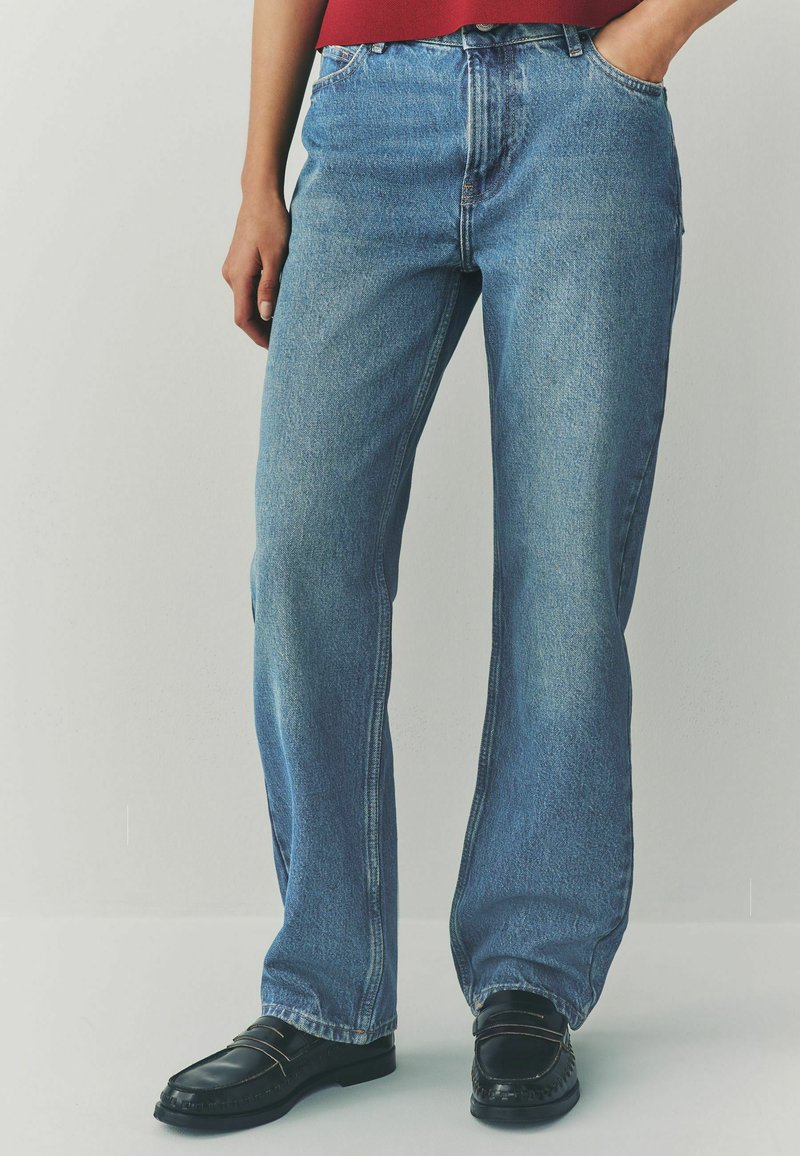 Jeans dritti azzurro chiaro realizzati in denim. Presentano una vita alta, un classico design a cinque tasche e una leggera sbiaditura. Abbinati a mocassini neri.