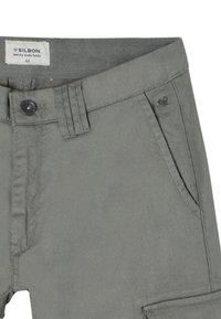 Pantalones de algodón grises con cierre de botón, bolsillos delanteros y un pequeño logo bordado en el lateral. Corte clásico con una textura suave.