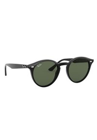 Occhiali da sole tondi neri con lenti verdi, caratterizzati da una finitura lucida e un discreto marchio Ray-Ban sulle tempie.