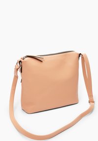 Brzoskwiniowa skórzana torba na ramię o fakturze z drobnymi wypukłościami, z zamknięciem na zamek błyskawiczny i regulowanym paskiem. Minimalistyczny design bez widocznych wzorów.