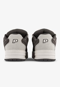 Szürke és fehér sportcipők, texturált velúrból készült felsőrésszel, hálós részletekkel, párnázott bokaredővel és egy feltűnő "P" logóval a saroknál.